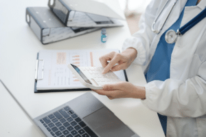 medical personnel holding a calculator while checking bills